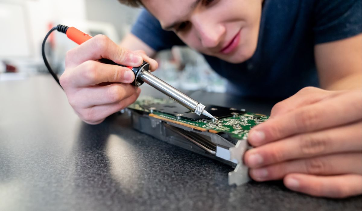 A student adjust a circuit board as part of this training via Iowa Valley Community College.