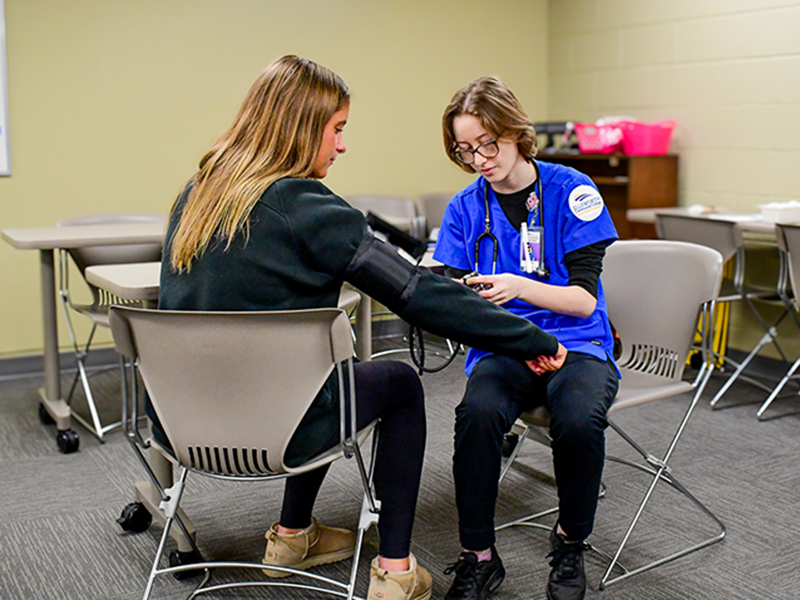 Nursing student practicing inserting shots.