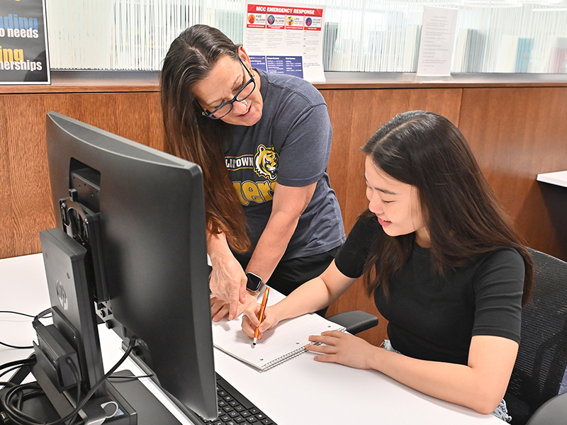 success specialist helping a student on the computer