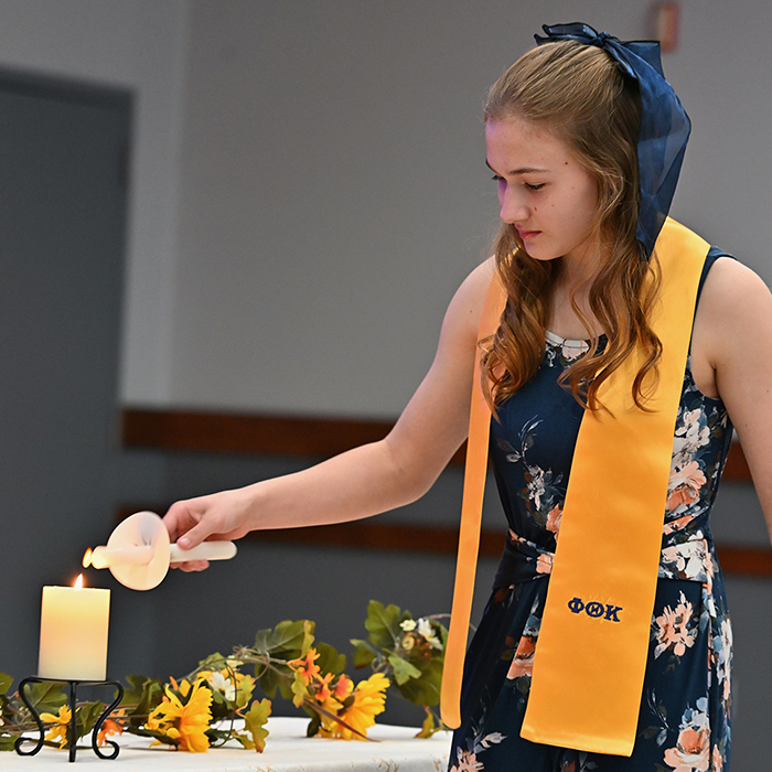 student lighting candle