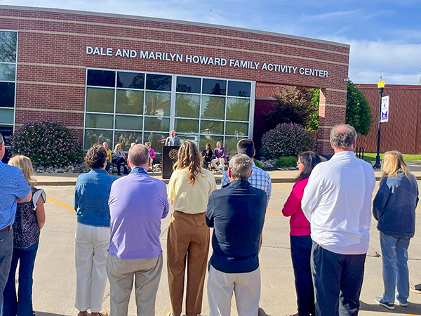 A group of people gathered outside the Dale and Marilyn Howard Family Activity Center at Ellsworth Community College on May 9, 2026, during the rededication ceremony.