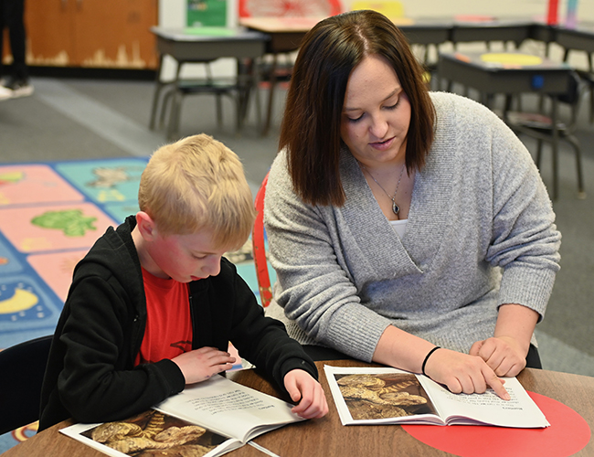 college student working with elementary student