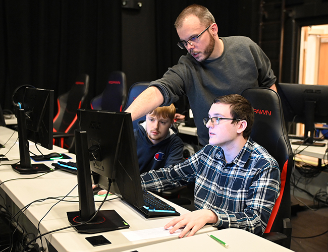 Instructor working with student for seting up Esports event