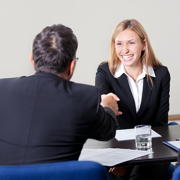 woman shaking hands and smiling at interview